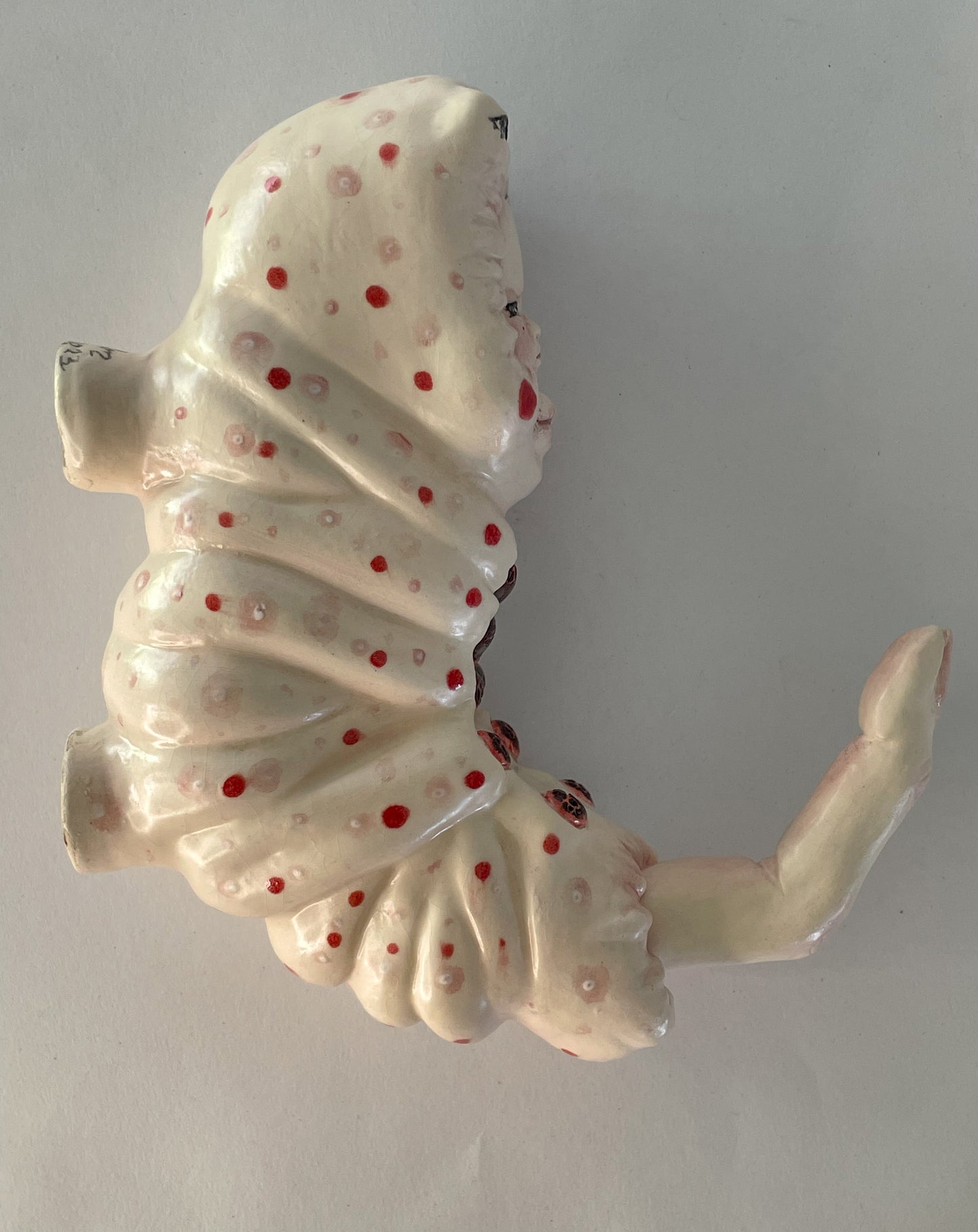 Escultura de bebé triste por su propia existencia en rojo