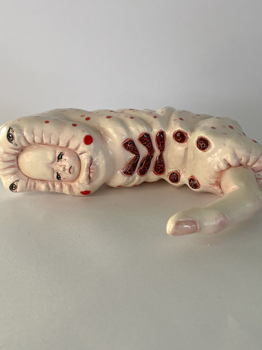 Escultura de bebé triste por su propia existencia en rojo