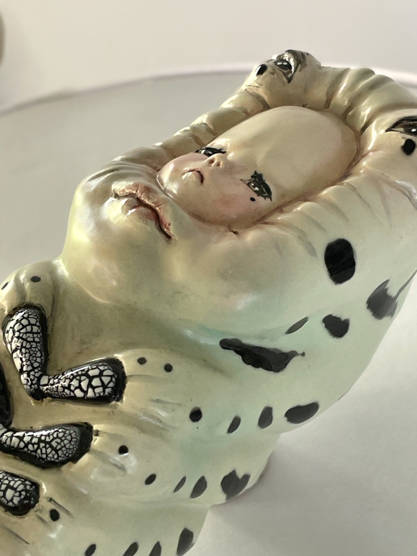 Escultura de bebé triste por su propia existencia en verde
